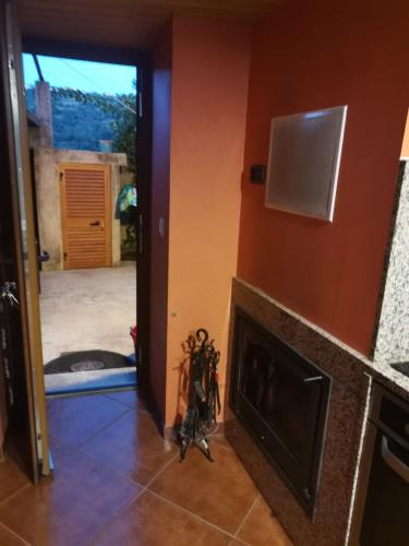 a living room with a fireplace and an open door at Casa da Gracita in Pereira