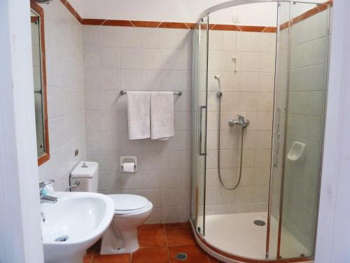 a bathroom with a shower and a toilet and a sink at Milia Bay Hotel Apartments in Milia