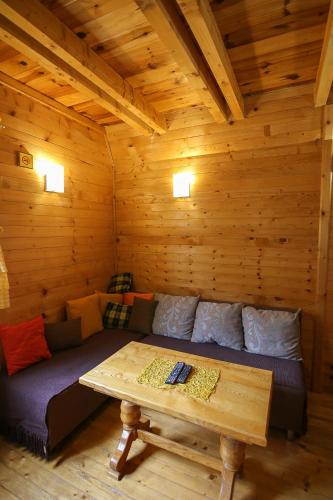 a room with a couch and a table in a cabin at Lodge Drveni Kutak in Sekulić 