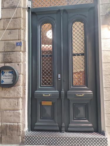 a gray door with two windows on a building at TheJoy Residence Apartments in Chania Town