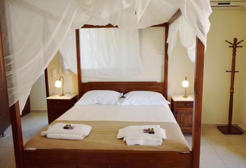 Schlafzimmer mit einem Bett mit weißer Bettwäsche und Handtüchern in der Unterkunft Villa Helidoni in Pondikianá