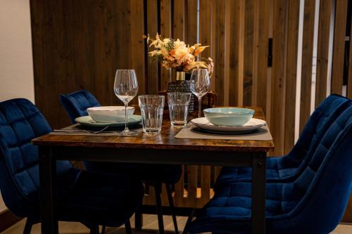 a wooden table with wine glasses and bowls on it at 24-7 Apartments Passau - Ferienwohnung in Passau