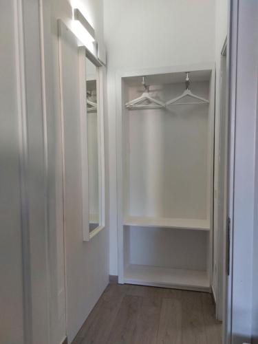a walk in closet with white walls and a mirror at B&B Il Gabbiano in Cittadella del Capo