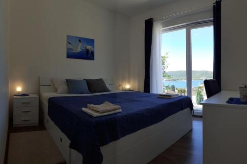 a bedroom with a bed with blue sheets and a window at Vis - luxury holiday villa with swimming pool in Vis