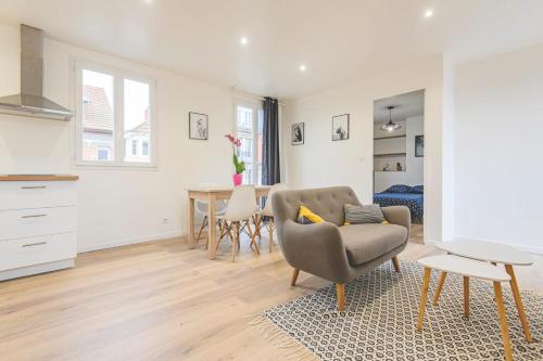 un salon avec une chaise et une table dans l'établissement Appartement lumineux proche Cathédrale, à Reims