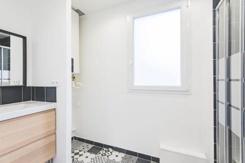 ein Bad mit einem Waschbecken und einem Fenster in der Unterkunft Appartement lumineux proche Cathédrale in Reims
