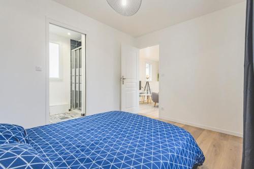 a white bedroom with a blue bed and a mirror at Appartement lumineux proche Cathédrale in Reims