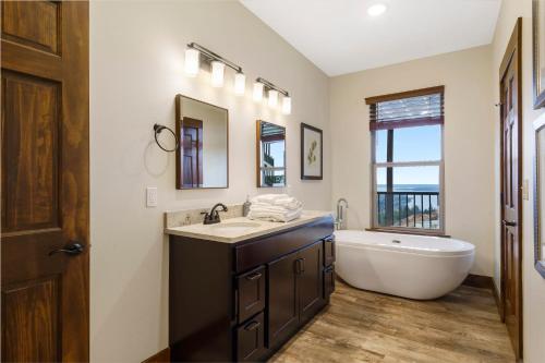 a bathroom with a tub and a sink and a bath tub at Beautiful Branson Lodge Close to All the Action in Branson