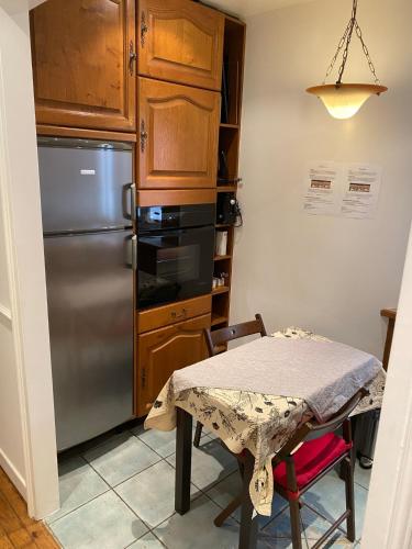 une cuisine avec une table et un réfrigérateur dans l'établissement Bel Appartement Haussmannien - Gare de Lyon, à Paris