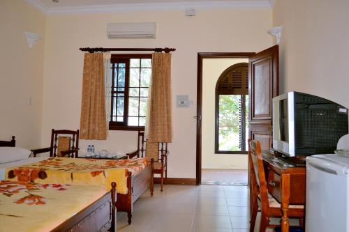 a bedroom with two beds and a television in it at Huong Sen 2 Hotel in Vung Tau