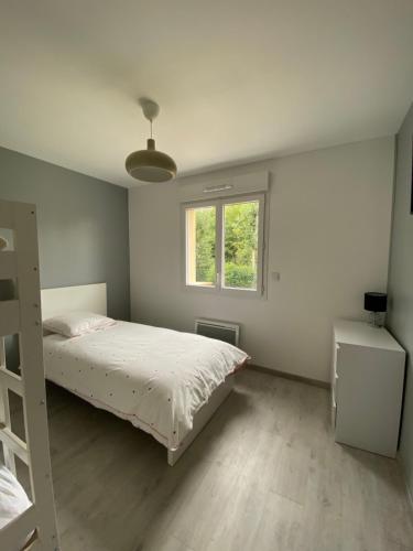 biała sypialnia z łóżkiem i oknem w obiekcie Maison au cœur de la nature w mieście Cerisy-la-Forêt