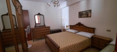 Schlafzimmer mit einem Bett, einer Kommode und einem Spiegel in der Unterkunft Marchesana Terme - Holiday Home - Family in Terme Vigliatore