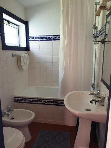 a bathroom with a sink and a tub and a toilet at Sondela Self Catering in São Martinho do Porto