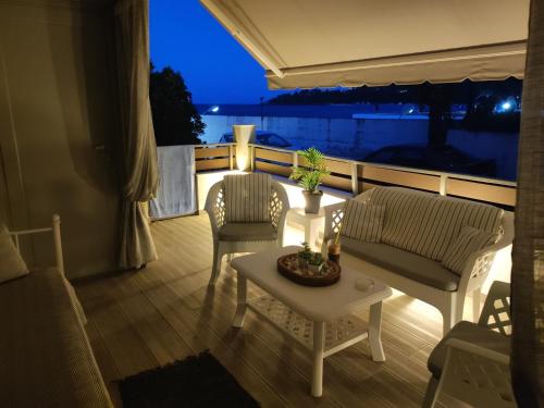uma varanda com 2 cadeiras e uma mesa com vista em Sweet home em Poros