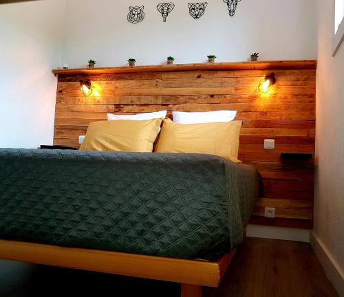 Una cama con cabecero de madera con luces. en L'Original, Superbe appartement à 5min de la plage, en Zonza