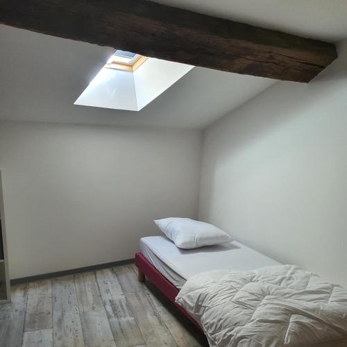 - une chambre avec un lit et une lucarne dans l'établissement Gîte Manapany, à Fains-les-Sources