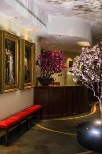 a room with a red bench and a vase with flowers at Lux Garden Hotel in Azuga
