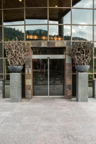a building with two large vases in front of it at Lux Garden Hotel in Azuga