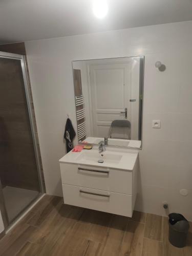 y baño con lavabo y espejo. en Bonjour appartement T2 neuf., en Malleval