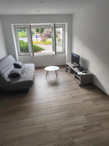 sala de estar con sofá y mesa en Bonjour appartement T2 neuf., en Malleval