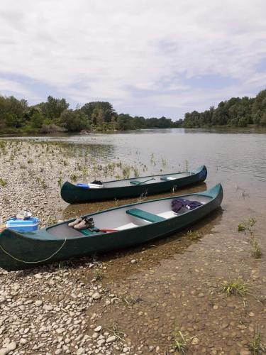 three canoes sitting on the shore of a river at Sobe Pilajevo 2, 183 Ulica Stjepana Radića, Gola in Gola
