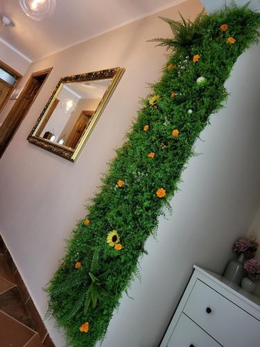 a green ivy wall with flowers on a wall at Sobe Pilajevo 2, 183 Ulica Stjepana Radića, Gola in Gola