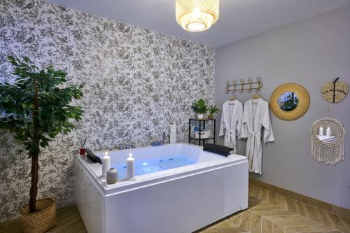a bathroom with a tub with a potted tree in it at Spa, Love & Relax in Périgueux