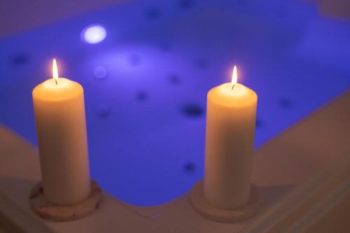 two white candles sitting on top of a table at Spa, Love & Relax in Périgueux