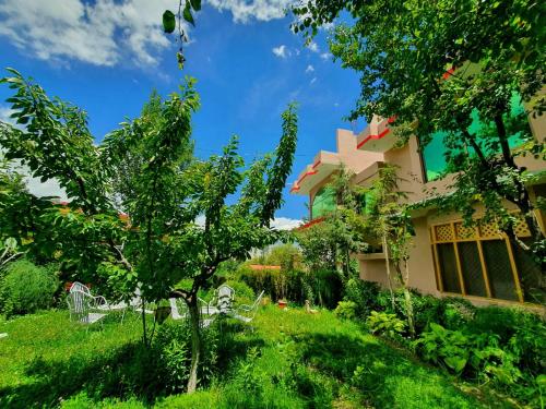 a house in the middle of a yard with trees at HIKK Inn in Skardu