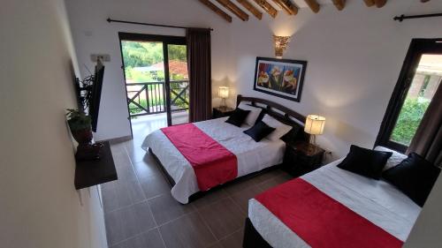 una camera con 2 letti e un balcone di Villa Lupalú - Fincas Panaca- a El Laurel