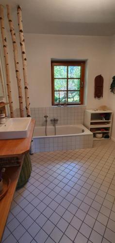 a bathroom with a tub and a sink and a window at Ferienwohnung Wybo mit Garten in Wremen