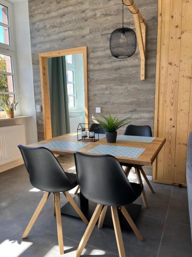 ein Esszimmer mit einem Holztisch und schwarzen Stühlen in der Unterkunft Alte Schule Seinsfeld 