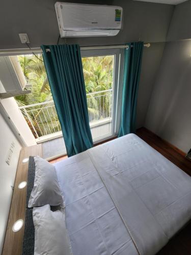 Habitación pequeña con cama y ventana en GDC - Apartment suites en Ernakulam