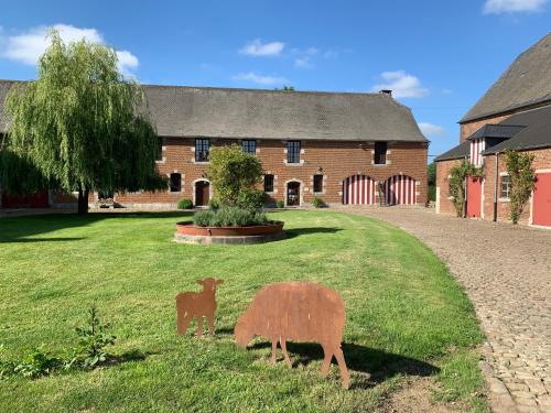 a house with a statue of a deer in front of it at La Bergerie, gîte à la ferme, 3 épis in Walcourt