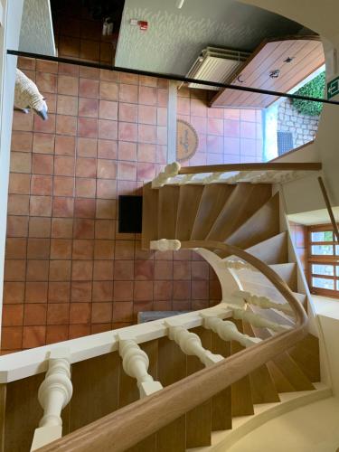 a spiral staircase in a building with a tile floor at La Bergerie, gîte à la ferme, 3 épis in Walcourt