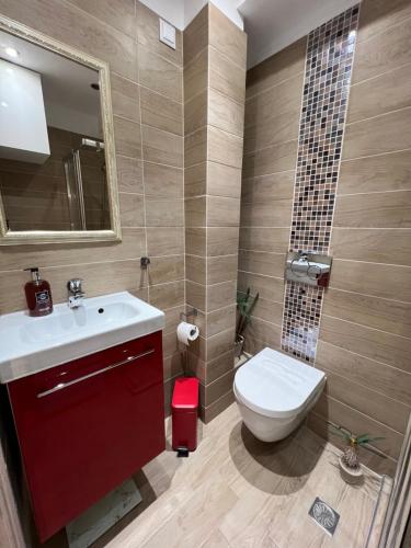 La salle de bains est pourvue de toilettes blanches et d'un lavabo. dans l'établissement Vicky’s studio, au Pirée