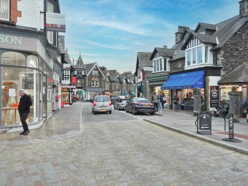 a street in a town with cars driving down the street at Broadlands Windermere in Windermere