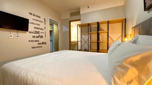 a bedroom with a large white bed and a television at STD - Anora Spaces - Stadium Alphaville in Barueri