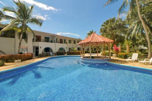 uma grande piscina com um gazebo ao lado de um edifício em Lovely 2-BDroom Condo in Laguna Eco Village Resort em Quepos