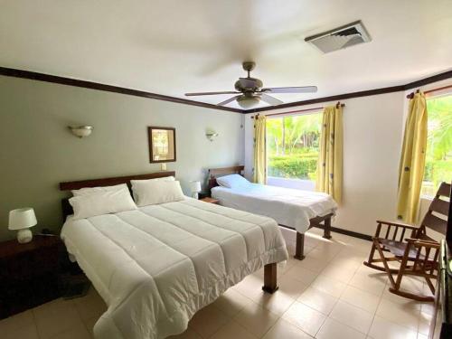 - une chambre avec 2 lits et un ventilateur de plafond dans l'établissement Lovely 2-BDroom Condo in Laguna Eco Village Resort, à Quepos