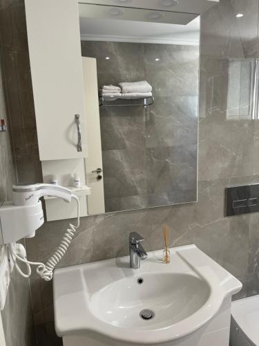 薩蘭達的住宿－Hotel LIDI，浴室设有白色水槽和镜子