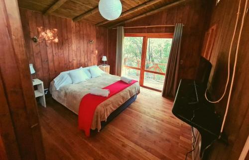 1 dormitorio con 1 cama en una habitación con ventana en Cabañas Piedra Luna, en San Alfonso