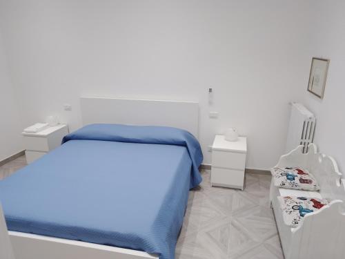 ein weißes Schlafzimmer mit einem Bett und zwei Nachttischen in der Unterkunft U' Pastus in Bari