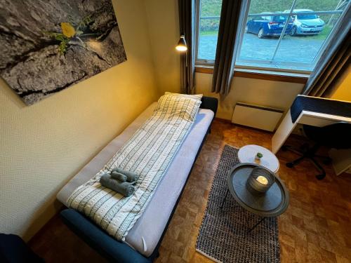 um pequeno quarto com uma cama com um ursinho de peluche em Privat rom i leilighet em Sogndal