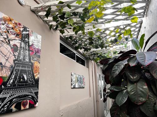 una habitación con una planta y fotos de la torre Eiffel en Casa Boston Inn, en Barranquilla