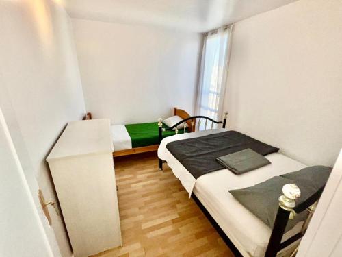 a small room with two beds and a window at Superbe appartement près du métro 4 proche Paris in Bagneux