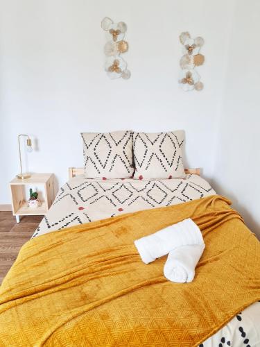 une chambre avec un lit avec deux serviettes dessus dans l'établissement Le Petit Charmeur, parking, Wifi, gare, à Flers