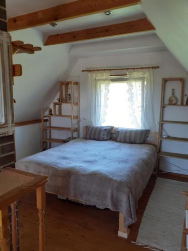 a bedroom with a large bed with a window at Dīķīši in Daugavpils