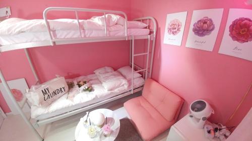 a pink room with a bunk bed and a chair at Spring Light in Seoul