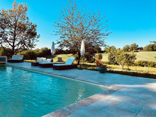 una piscina con sofás y sombrillas junto a en Manoir du Suquet, en Bardou